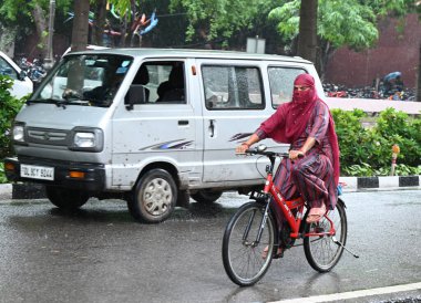 NEW DELHI, INDIA - 10 AĞUSTOS: 10 Ağustos 2024 tarihinde Yeni Delhi, Hindistan 'da sağanak yağış sırasında görülen insanlar. 