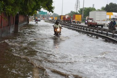 GURUGRAM, INDIA - 27 Temmuz 2024: Araçlar, 27 Temmuz 2024 'te Gurugram, Hindistan' da, İmza Kulesi Chowk yakınlarındaki National Highwway-48 'de yağmurdan sonra su dolu bir alanda yürüdüler.