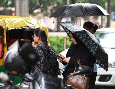 NEW DELHI, INDIA - 10 AĞUSTOS: 10 Ağustos 2024 tarihinde Yeni Delhi, Hindistan 'da sağanak yağış sırasında görülen insanlar. 