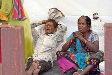 NEW DELHI, INDIA - 11 Temmuz 2023 'te Yeni Delhi, Hindistan' da muson yağmurları nedeniyle Yamuna Nehri 'nin taşması sonrasında alçak bölgelerden taşındıktan sonra Demir Pul yakınındaki insanlar sığınağa sığındı..  