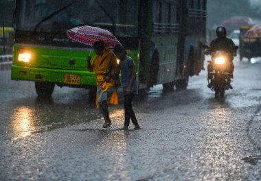 NEW DELHI, INDIA - 10 Temmuz 2023 'te Hindistan' ın Yeni Delhi kentinde şiddetli yağmurların şehri kasıp kavurmasından sonra, banliyö sakinleri su dolu bir caddede hareket ediyor.. 