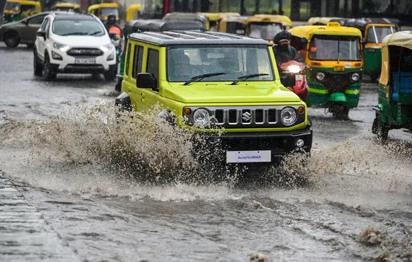 stock image NEW DELHI, INDIA - JULY 10: Commuters moves through a water logged street after heavy rains lashes out the city at ITO kabristan Lane on July 10, 2023 in New Delhi, India. 