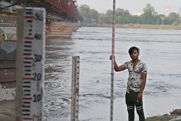 NEW DELHI, INDIA - 26 Temmuz 2023 'te Yeni Delhi, Hindistan' da Yamuna su geçişi sonrasında su seviyesini kontrol eden Merkez Su Komisyonu çalışanları. 