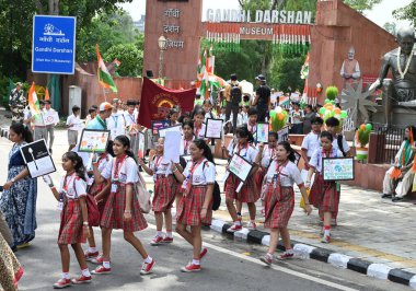 NEW DELHI, INDIA - AUGUST 9, 2024: School children with National Flag and Placards raising awareness on Social Evils as part of Har Ghar Tiranga Abhiyaan march from Gandhi Darshan, Rajghat to Charti Lal Goel Heritage Park near Red Fort. clipart