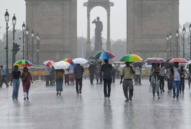 NEW DELHI, INDIA - 10 Temmuz 2023 tarihinde Yeni Delhi, Hindistan 'da Kartvaya Yolu' nda sağanak yağmur sırasında ziyaretçiler. Hindistan 'ın kuzeybatısında 40 yıllık bir rekor kıran şiddetli bir yağmura tanık oldu..