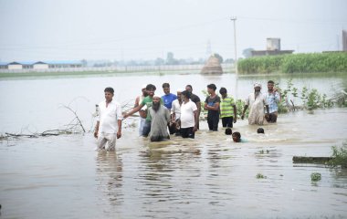 GHAZIABAD, INDIA - 15 Temmuz 2023 'te Gaziabad' ın Loni ilçesindeki Yamuna nehrinden gelen sel suları nedeniyle evleri ve köyleri sular altında kalırken, Gaziabad 'da selden etkilenen yüzlerce vatandaş Alipur sehpinde kalıyor.