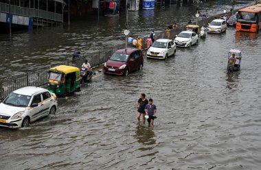 NEW DELHI, INDIA - 15 Temmuz 2023 tarihinde Yeni Delhi, Hindistan 'da şiddetli muson yağmurlarının ardından, Yamuna Nehri' nin su seviyelerinin yükselmesi nedeniyle, Banliyö sakinleri sular altında kalan ITO Vikas Marg boyunca yol aldılar. Nehrin su seviyesi yükseldi.