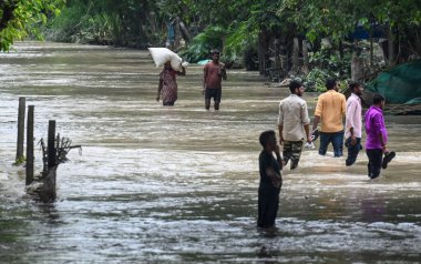 15 Temmuz 2023 'te Yeni Delhi, Hindistan' da Mayur Vihar Side 'da, Yamuna nehrinin su seviyesinin yükselmesinin ardından insanlar sel basmış bir yolda yürüdü.. 