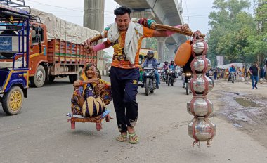 Gaziabad, Hindistan - Temmuz 07 2023: Dev, 7 Temmuz 2023 tarihinde Hindistan 'ın Gaziabad kentinde, Ganga Nehri' nin bir omzunda ve diğer omzunda annesini taşıyan bir genç. Fotoğraf: Sakib Ali / Hindustan Times)