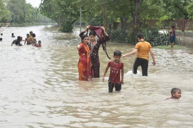 Yeni DELHI, INDIA - 15 Temmuz 2023 'te Hindistan' ın Yeni Delhi kentinde, şiş Yamuna nehri yakınlarındaki bölgeleri sular altında bırakırken, Shantivan yakınlarında tufan sularında eğlenen insanlar. Nehrin su seviyesi Çarşamba gününden beri yükseliyor.-
