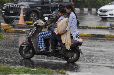 GURUGRAM, INDIA - 4 Temmuz 2023 tarihinde Hindistan 'ın Gurugram kentinde, Mini Secretariat yakınlarındaki Rajiv chowk' ta, ağır muson yağmurları altında banliyö sakinleri görülüyor. (Fotoğraf: Parveen Kumar / Hindustan Times)