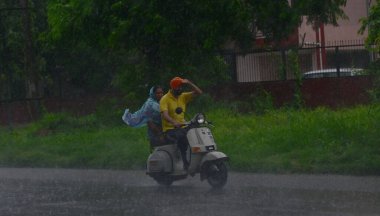 8 Temmuz 2023 'te Chandigarh, Hindistan' da, sağanak yağış sırasında banliyöden geçenler. (Fotoğraf: Ravi Kumar / Hindustan Times )