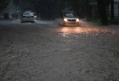 8 Temmuz 2023 'te Hindistan' ın Yeni Delhi kentinde, Bangla Sahab Marg 'da sağanak yağış sonrasında, araçlar sularda yürür. Delhi-NCR, Cuma ve Cumartesi gecesi şiddetli yağmura tutuldu..