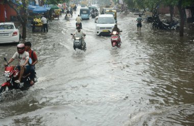 GHAZIABAD, INDIA - 9 Temmuz 2023 'te Hindistan' ın Gaziabad kentinde, Nand naram ana yolunda muson yağmurları sırasında, banliyö sakinleri su boyunca yürüdüler. Delhi-NCR, Cuma, Cumartesi ve Pazar gecelerinde şiddetli yağmura boğuldu.. 