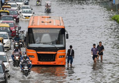 NEW DELHI, INDIA - 15 Temmuz 2023 tarihinde Yeni Delhi, Hindistan 'da şiddetli muson yağmurlarının ardından, Yamuna Nehri' nin su seviyelerinin yükselmesi nedeniyle, Banliyö sakinleri sular altında kalan ITO Vikas Marg boyunca yol aldılar. Nehrin su seviyesi yükseldi.