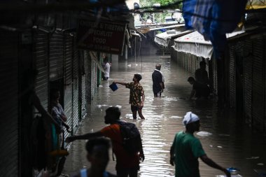 NEW DELHI, INDIA - 15 Temmuz 2023 'te Yeni Delhi, Hindistan' da Tibet Pazarı 'ndaki sel baskınından sonra dükkan sahipleri dükkanlarını temizlerken görüldü. Nehrin su seviyesi Çarşamba gününden beri yükseliyor.