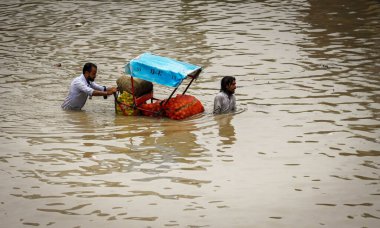 14 Temmuz 2023 'te Yeni Delhi, Hindistan' da, Yamuna Bazar Bölgesi 'nde, şiddetli muson yağmurları sonrasında Yamuna nehrinin su seviyesinde yükselen insanlar sel basmış bir yolda yürürler. Fotoğraf: Raj K Raj / Hindustan Times)