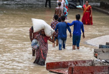 15 Temmuz 2023 'te Yeni Delhi, Hindistan' da Mayur Vihar Side 'da, Yamuna nehrinin su seviyesinin yükselmesinin ardından insanlar sel basmış bir yolda yürüdü.. 