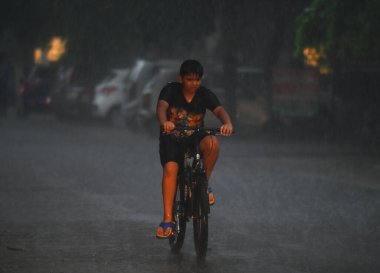NOIDA, INDIA - 26 Temmuz 2023 'te Noida, Hindistan' da 12. Bölge yolundaki sağanak yağış sırasında banliyö sakinleri görüldü. Delhi-NCR sakinleri şiddetli yağış gördü. Banliyö sakinleri pek çok alanda su bloklama nedeniyle sorunlarla karşılaştı. IMD öngördü.