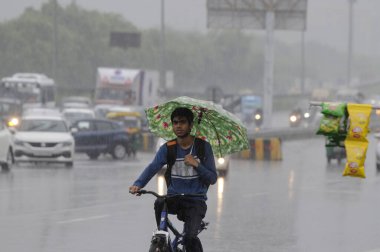 GURUGRAM, INDIA - 8 Temmuz 2023 'te Hindistan' ın Gurugram kentinde, Sektör-32 'ye yakın bir muson yağmuru sırasında, Ulusal Otoyol-48 boyunca ilerlediler. Delhi-NCR, Cuma ve Cumartesi gecelerinde şiddetli yağmurdan sırılsıklam olmuştu. Şey...