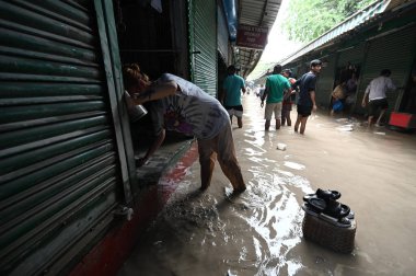 NEW DELHI, INDIA - 15 Temmuz 2023 'te Yeni Delhi, Hindistan' da Tibet Pazarı 'ndaki sel baskınından sonra dükkan sahipleri dükkanlarını temizlerken görüldü. Nehrin su seviyesi Çarşamba gününden beri yükseliyor.
