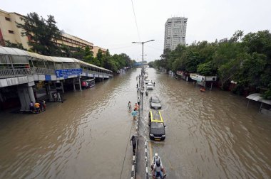 Yeni DELHI, INDIA - 14 Temmuz 2023 tarihinde Yeni Delhi, Hindistan 'da şiddetli muson yağmurlarının ardından, Yamuna nehrinin su seviyelerinin yükselmesi nedeniyle, banliyö sakinleri sular altında kalan ITO yolundan geçtiler. (Fotoğraf: Sanjeev Verma / Hindustan Times)