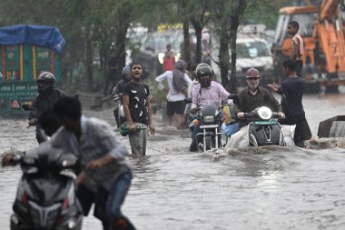 8 Temmuz 2023 'te Yeni Delhi, Hindistan' da Rohtak Yolu 'ndaki yoğun yağış sonrası, banliyö sakinlerinin sularda hareket ettiği görüldü. Delhi-NCR, Cuma ve Cumartesi gecelerinde şiddetli yağmurdan sırılsıklam olmuştu. Gecelik.