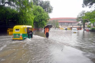 NEW DELHI, INDIA - 9 Temmuz 2023 'te, Hindistan' ın Yeni Delhi kentinde, Anayasa Mahkemesi yakınlarındaki şiddetli yağmurlar altında, banliyö sakinleri geniş bir alanda hareket ediyorlar. Delhi-NCR, Cuma, Cumartesi ve Sunda gecelerinde şiddetli yağmura boğuldu.