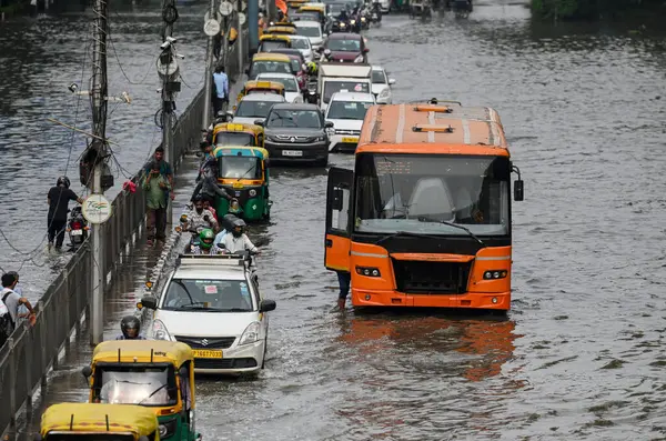 NEW DELHI, INDIA - 15 Temmuz 2023 tarihinde Yeni Delhi, Hindistan 'da şiddetli muson yağmurlarının ardından, Yamuna Nehri' nin su seviyelerinin yükselmesi nedeniyle, Banliyö sakinleri sular altında kalan ITO Vikas Marg boyunca yol aldılar. Nehrin su seviyesi yükseldi.