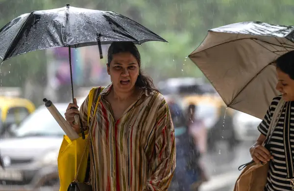 MUMBAI, INDIA - 26 Temmuz 2023 'te Hindistan' ın Mumbai şehrinde insanlar yoğun yağmurdan geçiyorlar. Fotoğraf: Satish Bate / Hindustan Times)