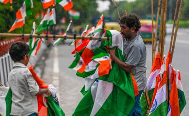 NEW DELHI, INDIA - 14 Ağustos 2024: Bağımsızlık Günü kutlamaları öncesinde Hindistan bayrakları satan bir satıcı, 14 Ağustos 2024 'te Yeni Delhi, Hindistan' da Akshardham Tapınağı yakınlarında.