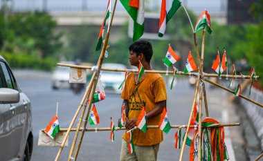 NEW DELHI, INDIA - 14 Ağustos 2024: Bağımsızlık Günü kutlamaları öncesinde Hindistan bayrakları satan bir satıcı, 14 Ağustos 2024 'te Yeni Delhi, Hindistan' da Akshardham Tapınağı yakınlarında.
