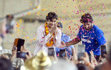 Destekçiler, Wrestler Vinesh Phogat 'a 17 Ağustos 2024' te Hindistan 'ın Yeni Delhi kentindeki Dawarka Ekspres yolundaki IGI havaalanına gelişinde çiçeklerle hoş geldiniz diyor..