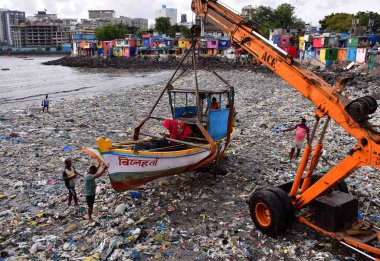 MUMBAI INDIA - 5 Haziran 2024 'te, Dünya Çevre Günü Colaba' da, Dünya Çevre Günü Colaba yakınlarında, Badhwar Park yakınlarında tonlarca plastik atık arasında bir vinç yardımıyla balıkçılar teknelerini çıkardılar. (Fotoğraf: Bhushan Koyande / Hindustan Times)