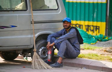 NEW DELHI INDIA - 31 Mayıs 2024 tarihinde Delhi-NCR 'de sıcaklık yükselirken sıcak yaz mevsiminde Kartvaya Yolu Otoparkı' nda sıcak hava dalgasına göğüs geren bir temizlikçi. Delhi ve Gurgaon Noida Fari 'yi kapsayan ulusal başkent