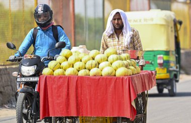 Yeni DELHI INDIA - 31 Mayıs 2024 yılında Yeni Delhi-NCR 'de sıcaklık yükselirken, Yeni Ashok Nagar yakınlarında bir Hawker yüzünü bir eşarpla kapatıyor. Delhi ve Gurgaon Noida Faridaba 'yı kapsayan ulusal başkent bölgesi