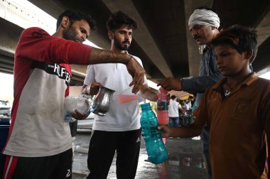 GURUGRAM INDIA - JUNE 1: Locals distribute Sharbat (sweet water) to passing by commuters on a hot summer day at Rajiv chowk near Civil Lines on June 1 2024 in Gurugram India. (Photo by Parveen Kumar/Hindustan Times  clipart