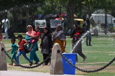 NEW DELHI INDIA - 2 Haziran 2024 'te Yeni Delhi Hindistan' da 2 Haziran 2024 'te Kartavya Yolu' ndaki yüksek sıcaklık dalgaları sırasında su fıskiyesinin yanında hareket eden insanlar görülüyor. (Fotoğraf: Salman Ali / Hindustan Times 