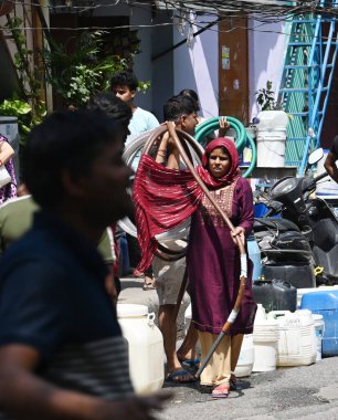 NEW DELHI INDIA - 2 Haziran 2024 'te Yeni Delhi Hindistan' da 2 Haziran 2024 'te Chanakyapuri' de meydana gelen yüksek sıcaklık dalgası sırasında Delhi Hükümeti 'nin bir ikmal tankerinden su dolduruluyor. Delhi 'de Chanakyapuri' nin Sa 'sı da dahil olmak üzere birkaç bölge