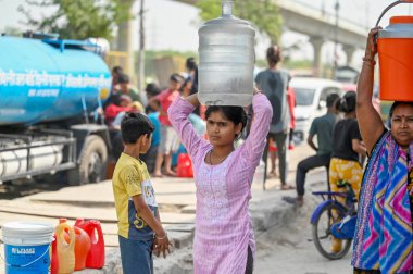 NEW DELHI INDIA - 3 Haziran 2024 Yeni Delhi Hindistan 'da 3 Haziran 2024 tarihinde Yeni Ashok Nagar bölgesinde meydana gelen sıcak hava dalgası sırasında Delhi hükümetinin ikmal su tankerinden su dolduruluyor. Delhi 'de Chanakyapuri de dahil olmak üzere birkaç bölge