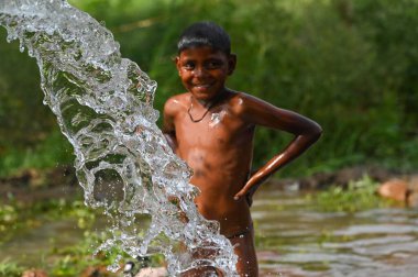 NEW DELHI INDIA - 3 Haziran 2024 Yeni Delhi Hindistan 'da 3 Haziran 2024 tarihinde Yamuna sel yatakları boyunca sıcak bir yaz günü öğleden sonra sıcak hava dalgasından biraz rahatlamak için su pompasının altında oynayan çocuklar. (Fotoğraf: Vipin Kumar / Hindustan Times 