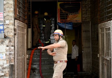 NOIDA INDIA - 3 Haziran 2024 itfaiye personeli Noida Hindistan 'da 3 Haziran 2024 tarihinde 10. Sektör' deki bir giysi fabrikasındaki yangını söndürdü. Soruşturma sırasında yangının kültivardaki kısa devre nedeniyle çıktığı ortaya çıktı.