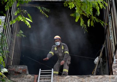 NOIDA INDIA - 3 Haziran 2024 itfaiye personeli Noida Hindistan 'da 3 Haziran 2024 tarihinde 10. Sektör' deki bir giysi fabrikasındaki yangını söndürdü. Soruşturma sırasında yangının kültivardaki kısa devre nedeniyle çıktığı ortaya çıktı.