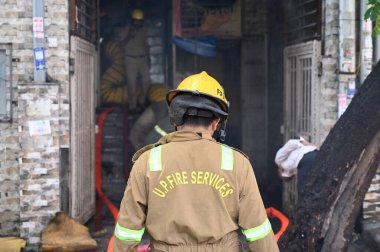 NOIDA INDIA - 3 Haziran 2024 itfaiye personeli Noida Hindistan 'da 3 Haziran 2024 tarihinde 10. Sektör' deki bir giysi fabrikasındaki yangını söndürdü. Soruşturma sırasında yangının kültivardaki kısa devre nedeniyle çıktığı ortaya çıktı.