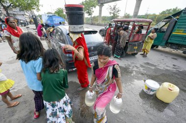 NEW DELHI INDIA 25 HAZİRAN 2024 Delhi Hükümeti 'nin ikmal tankerinden su dolduran insanlar 25 Haziran 2024' te Yeni Ashok Nagar bölgesinde yüksek sıcaklık dalgası sırasında Sanjeev Verma Hindustan Times