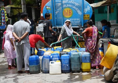 NEW DELHI, INDIA - 5 Haziran 2024 Yeni Delhi, Hindistan 'da 5 Haziran 2024 tarihinde Vasant Vihar yakınlarındaki Kusumpur Pahari su tankerindeki boş konteynerleri dolduran insanlar. Delhi 'de Chanakyapuri' nin Sanjay Kamp alanı ve Geeta kolonisi de dahil olmak üzere birkaç bölge