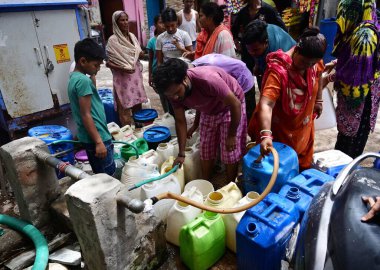 NEW DELHI, INDIA - 5 Haziran 2024 Yeni Delhi, Hindistan 'da 5 Haziran 2024 tarihinde Vasant Vihar yakınlarındaki Kusumpur Pahari su tankerindeki boş konteynerleri dolduran insanlar. Delhi 'de Chanakyapuri' nin Sanjay Kamp alanı ve Geeta kolonisi de dahil olmak üzere birkaç bölge