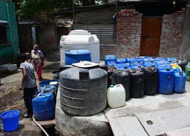 NEW DELHI, INDIA - 5 Haziran 2024 Yeni Delhi, Hindistan 'da 5 Haziran 2024 tarihinde Vasant Vihar yakınlarındaki Kusumpur Pahari' de su tankeri bekleyen evlerin önündeki boş konteynırlar. Delhi 'de Chanakyapuri' nin Sanjay Kamp alanı ve Ge bölgesi de dahil olmak üzere birkaç bölge.