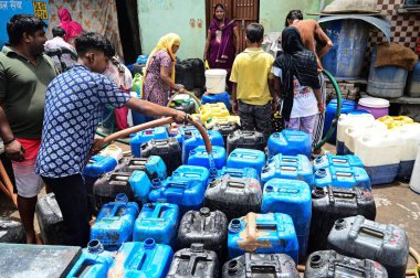 NEW DELHI, INDIA - 5 Haziran 2024 Yeni Delhi, Hindistan 'da 5 Haziran 2024 tarihinde Vasant Vihar yakınlarındaki Kusumpur Pahari su tankerindeki boş konteynerleri dolduran insanlar. Delhi 'de Chanakyapuri' nin Sanjay Kamp alanı ve Geeta kolonisi de dahil olmak üzere birkaç bölge