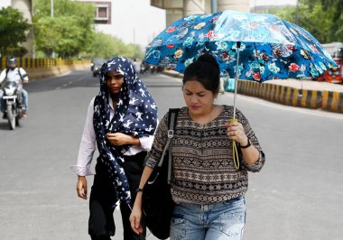 NOIDA, INDIA - JUNE 5 2024 Visitors brave the heat Wave during a hot summer afternoon, as the temperature rises in the Delhi-NCR, on June 5, 2024 in Noida, India. Several areas in Delhi including Chanakyapuri's Sanjay Camp area and the Geeta colony a clipart